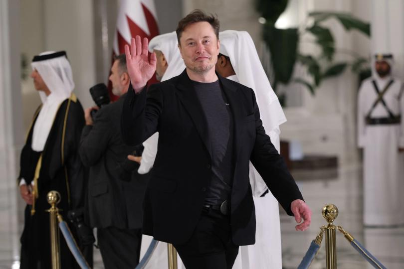 Elon Musk standing in front of a Tesla car and a SpaceX rocket.