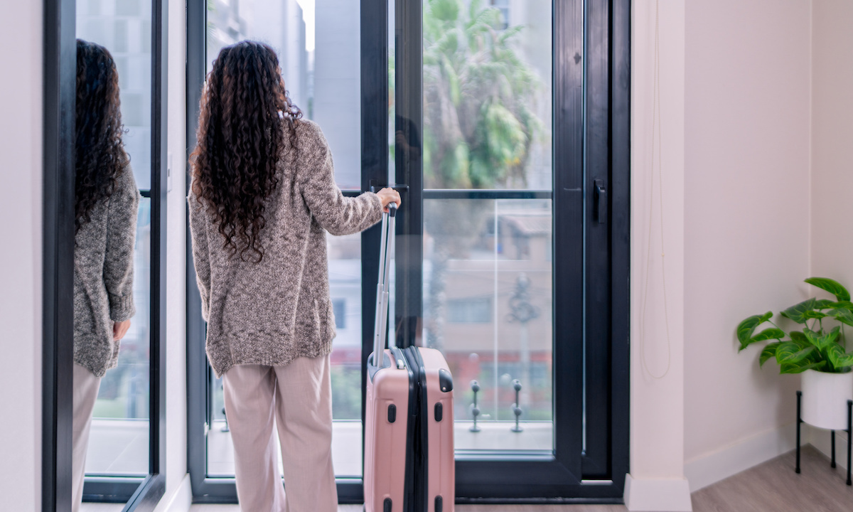 A person looking at a tablet displaying a dashboard with charts and graphs related to vacation rental management.