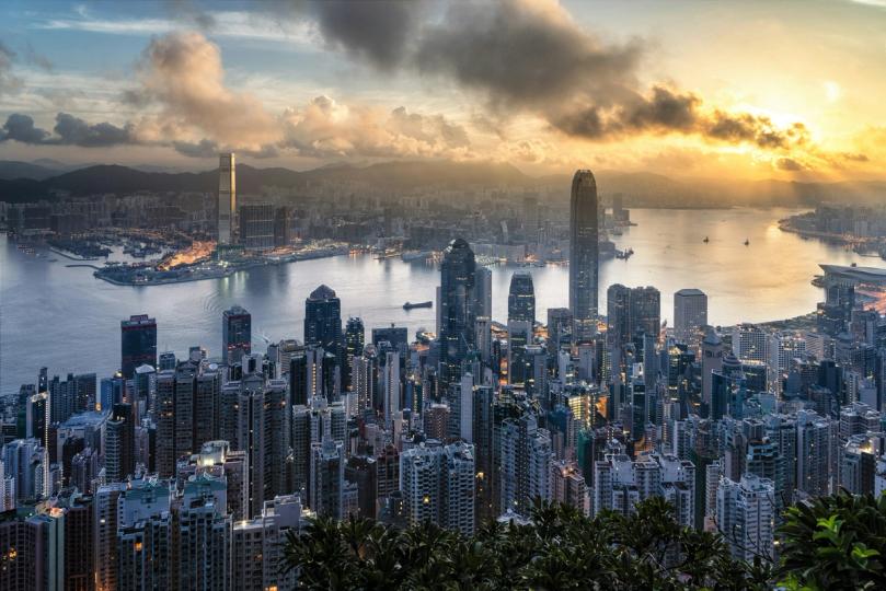 Hong Kong skyline with HSBC and Standard Chartered logos overlaid on stablecoin and blockchain graphics