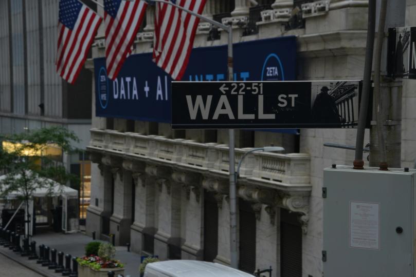 A graphic depicting a bank building with a digital currency symbol superimposed, facing off against a cryptocurrency coin.