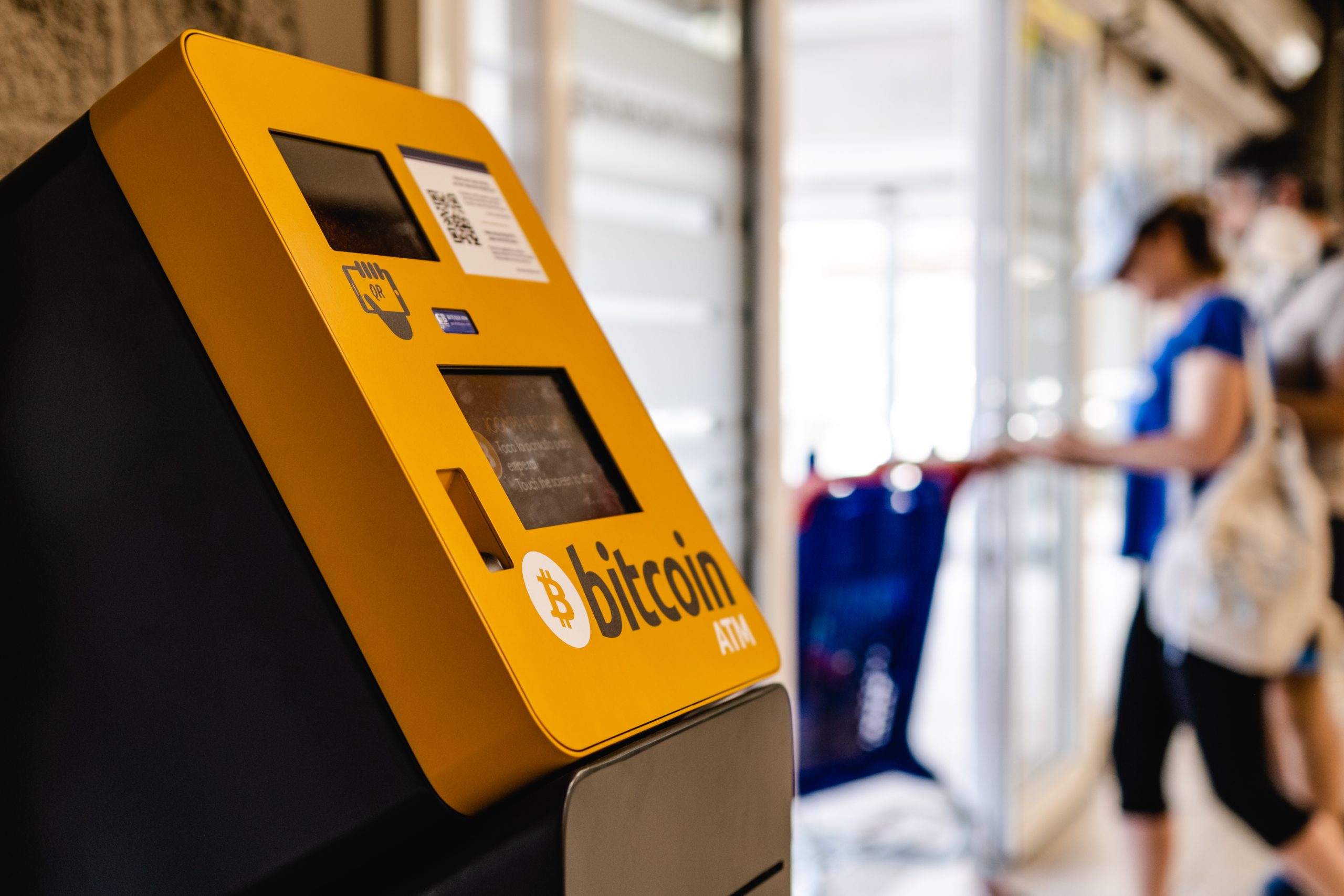 A Bitcoin ATM machine inside a convenience store, dimly lit.