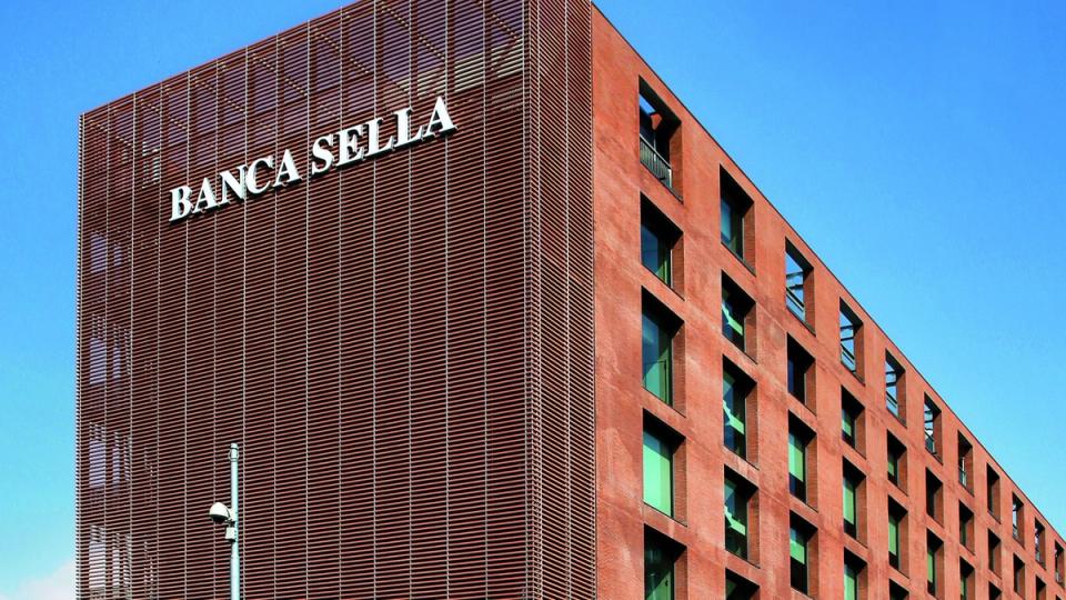 Banca Sella logo with a subtle digital currency graphic overlay